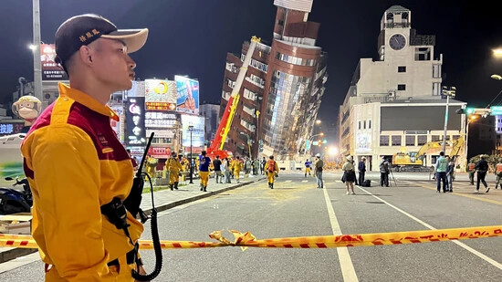 dpatopbilder - Ein Rettungshelfer steht in der Nähe der abgesperrten Stelle eines schiefen Gebäudes nach einem Erdbeben. Foto: Johnson Lai/AP/dpa