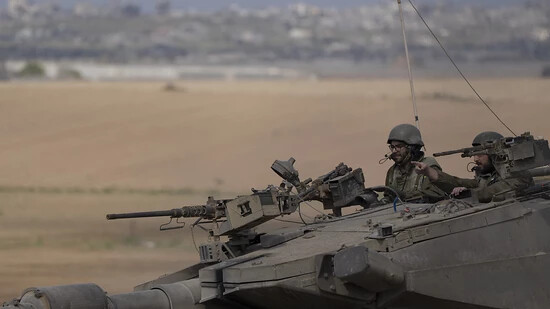 dpatopbilder - Israelische Soldaten fahren auf einem Panzer nahe der Grenze zwischen Israel und Gaza. Foto: Leo Correa/AP/dpa