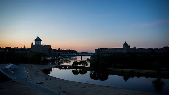 ARCHIV - Die Sonne geht hinter in der estnischen Stadt Narva und der russischen Burg Iwangorod unter. Foto: Kay Nietfeld/dpa