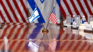 Eine israelische und eine US-Flagge spiegeln sich auf einem Konferenztisch: US-Verteidigungsminister Austin hat seinen israelischen Amtskollegen Galant im Pentagon empfangen. Foto: Jacquelyn Martin/AP/dpa