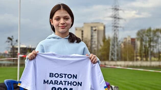 Die 12-jährige Ukrainerin Jana Stepanenko zeigt ein T-Shirt mit der Aufschrift "Boston Marathon 2024". Foto: ---/Ukrinform/dpa