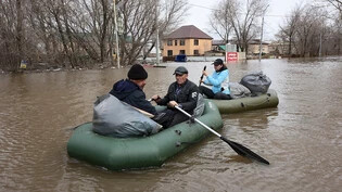 Anwohner paddeln in Schlauchbooten auf einer überfluteten Straße. Wegen Überschwemmungen wurden tausende Menschen in der Region Orenburg, die etwa 1.200 Kilometer südöstlich von Moskau liegt, evakuiert. Foto: v.v.smolnikov/AP/dpa