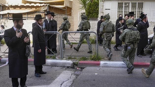 Israelische Sicherheitskräfte verfolgen die mutmaßlichen Angreifer nach einer Auto-Attacke, bei der drei Menschen verletzt wurden. Foto: Ohad Zwigenberg/AP/dpa